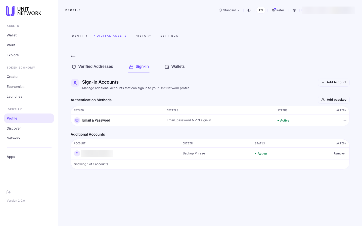 The Sign-In section of Digital Assets, reached from Profile. A section headed "Sign-In Accounts" reads "Manage additional accounts that can sign in to your Unit Network profile" with an Add Account control. An "Authentication Methods" table with an "Add passkey" control has columns METHOD, DETAILS, STATUS and ACTION, listing "Email & Password — Email, password & PIN sign-in — Active". An "Additional Accounts" table with columns ACCOUNT, ORIGIN, STATUS and ACTION lists one account originating from a Backup Phrase, marked Active, with a Remove control. The account pill and the account identifier are blurred.