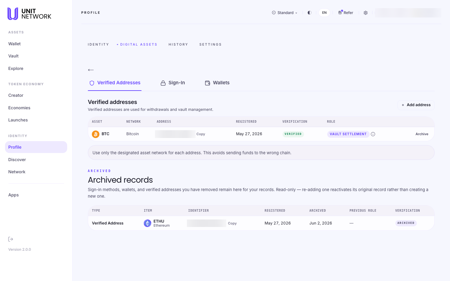 The Verified Addresses section of Digital Assets, reached from Profile. Profile tabs read IDENTITY, DIGITAL ASSETS, HISTORY and SETTINGS, and three section tabs read Verified Addresses, Sign-In and Wallets. A section headed "Verified addresses" notes they are used for withdrawals and vault management, with an "+ Add address" control. A table with columns ASSET, NETWORK, ADDRESS, REGISTERED, VERIFICATION and ROLE lists a Bitcoin address registered May 27 2026, marked VERIFIED with the role VAULT SETTLEMENT, and carrying Copy and Archive controls. A warning reads "Use only the designated asset network for each address. This avoids sending funds to the wrong chain." Below, an ARCHIVED section headed "Archived records" explains that removed items remain for your records, read-only, and that re-adding one reactivates its original record. Its table lists an archived Ethereum verified address registered May 27 2026 and archived Jun 2 2026. The account pill and the addresses are blurred.